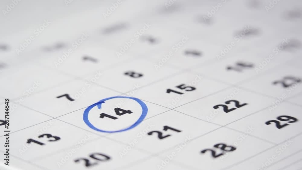Signing a day on a calendar with blue pen or marker. Putting date in circle. Valentine's day. Signing a day on a calendar with blue pen or marker. Putting date in circle. Valentine's day.