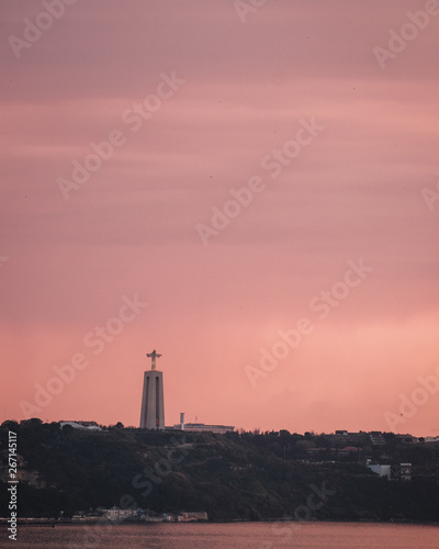 telephoto of Sanctuary of Christ the King (Santuario de Cristo Rei) in a dramatic sunset is Lisbon, Portugal