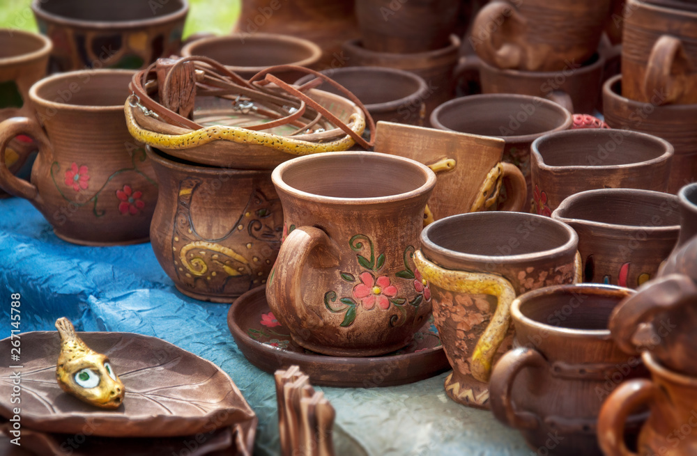 Pottery ceramic with glaze at the fair in Ukraine. Several types of pottery cups,  plates.