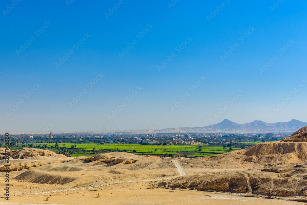 Naklejka premium Archeological site near the temple of Hatshepsut in Luxor, Egypt. Green landscape on a background