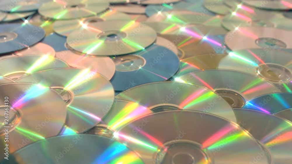 Sliding dolly along endless CD DVD data discs and stopping on a gold oneSliding along a sea of DVD or CD optical discs of gold green and silver, stopping on a gold one. Sliding dolly along endless CD DVD data discs and stopping on a gold oneSliding along a sea of DVD or CD optical discs of gold green and silver, stopping on a gold one.