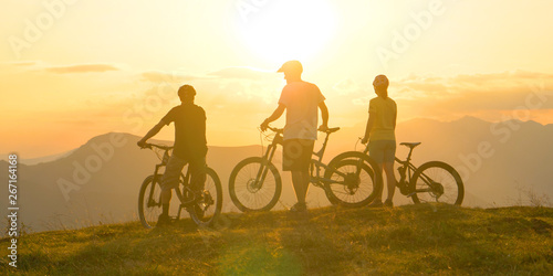 COPY SPACE Unrecognizable tourists watch the sunrise before mountain biking trip