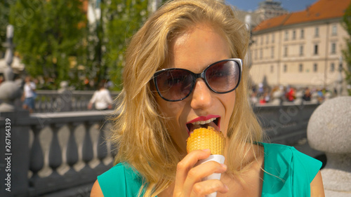 CLOSE UP  Tourist girl eating an ice cream cone while exploring Ljubljana.