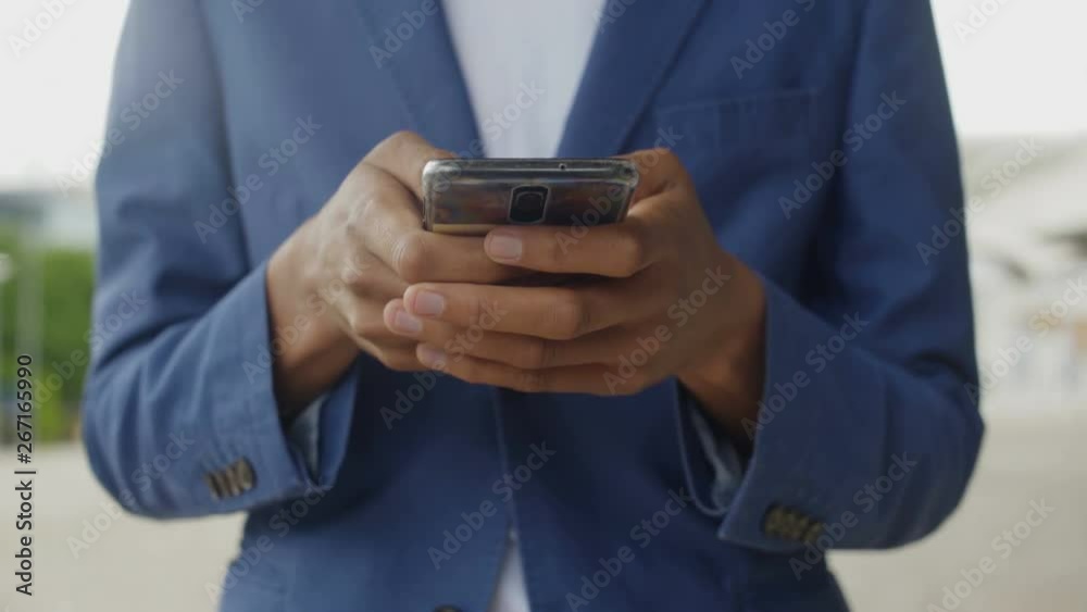 Front view of male hand using modern smartphone. Cropped shot of African American man wearing blue suit holding phone. Technology concept Front view of male hand using modern smartphone. Cropped shot of African American man wearing blue suit holding phone. Technology concept