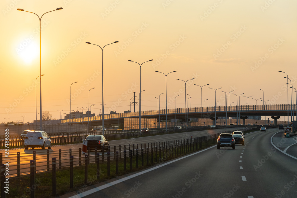 Road landscape, spring day and the setting orange sun.