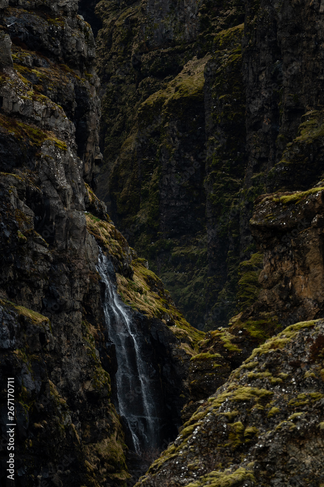 A small waterfall in a steep and rocky valley in Hvalfjörður, Iceland