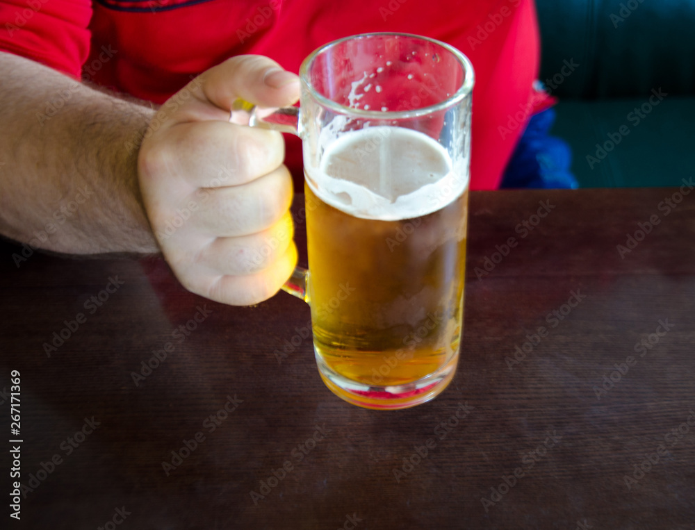 men's rough hands holding a glass of beer men's rough hands holding a glass of beer