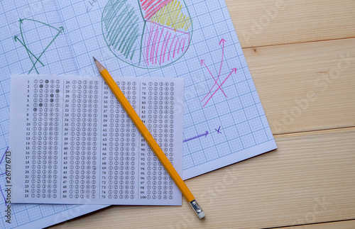 Success concept about education or examination.There are pencil,many charts on graph paper, answers sheet on wooden background