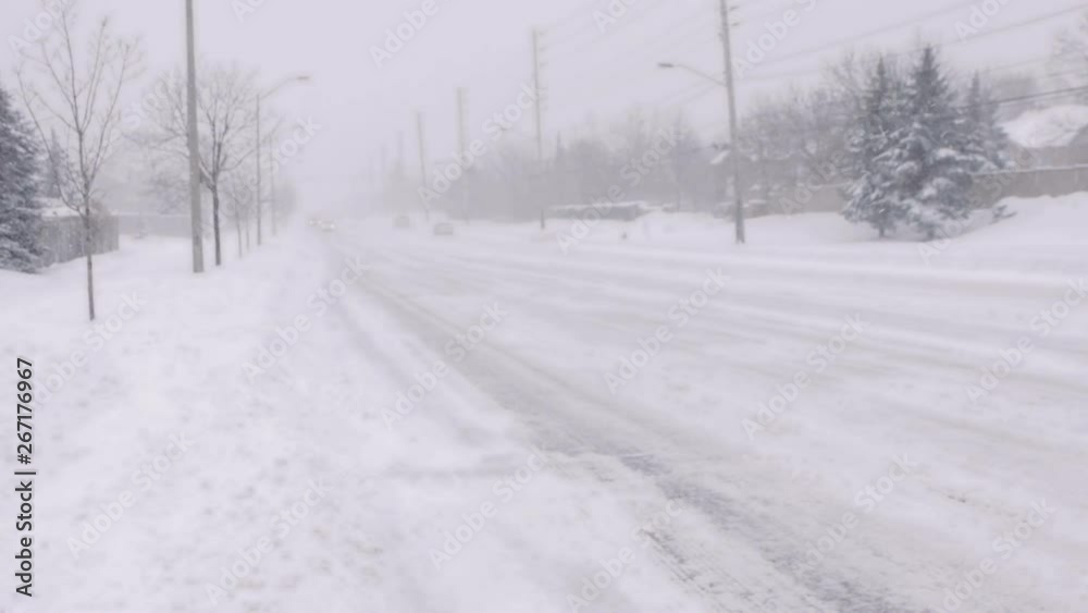 Cars driving through snowy street in a blizzard. It's dangerous to drive in such conditions. You should have stayed home, drivers! Cars driving through snowy street in a blizzard. It's dangerous to drive in such conditions. You should have stayed home, drivers!