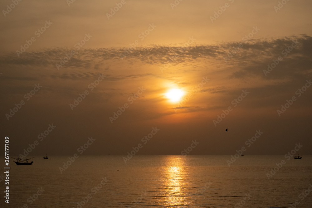 view of sunrise over the sea with fisheries boats