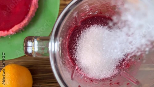 Adding sugar in blender with mixed berry smoothie