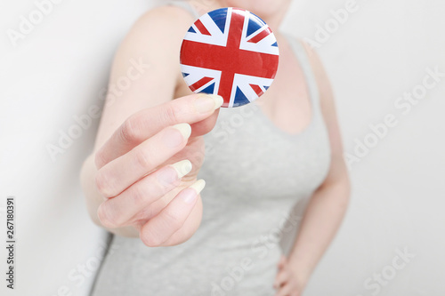The flag of Great Britain, printed on button badge, holding by woman