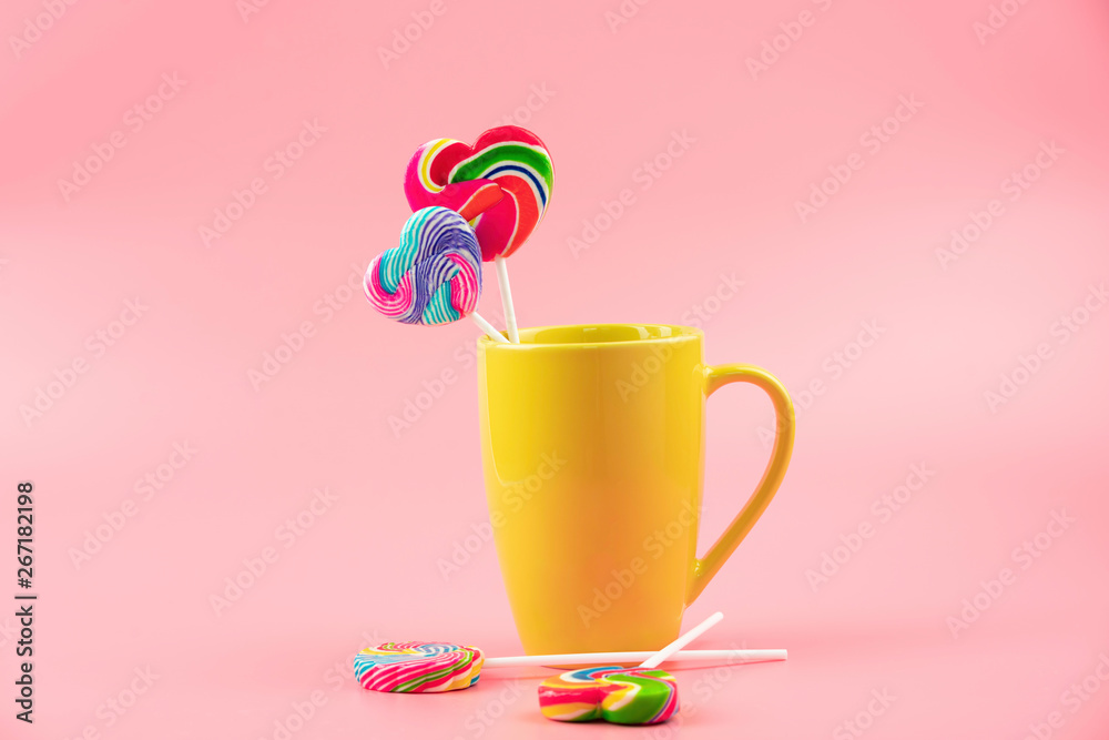 Multicolored lollipops in a container on a pink background Multicolored lollipops in a container on a pink background