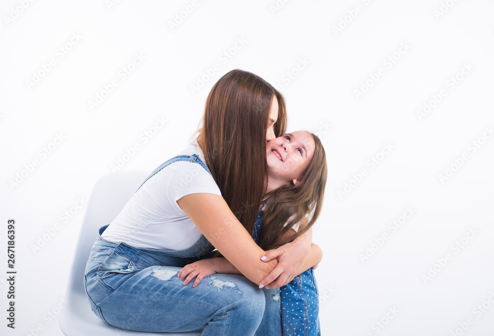 Family, children and parenthood concept - Young woman with her little cute child on white background. Mom with daughter isolated. Family, children and parenthood concept - Young woman with her little cute child on white background. Mom with daughter isolated.