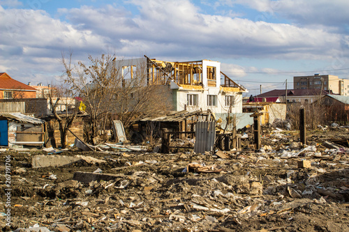 The destruction of the walls of the old building and the cleaning of construction debris with a bucket of an excavator