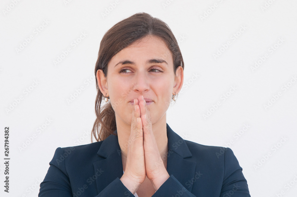 Positive office worker praying for luck. Young woman in office jacket putting hands together and keeping them near mouth and chin. Making wish concept Positive office worker praying for luck. Young woman in office jacket putting hands together and keeping them near mouth and chin. Making wish concept