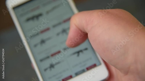 A man looking and chooses a weapons to buy on the site.