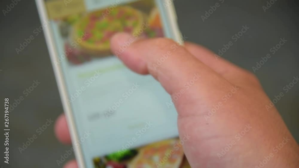 A man looking and chooses pizza on smartphone A man looking and chooses pizza on smartphone