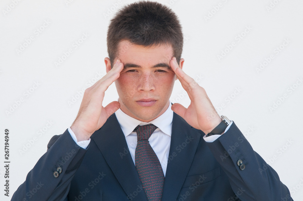 Upset young manager feeling headache. Young man touching head and staring onto vacancy. Migraine or bad sight concept Upset young manager feeling headache. Young man touching head and staring onto vacancy. Migraine or bad sight concept