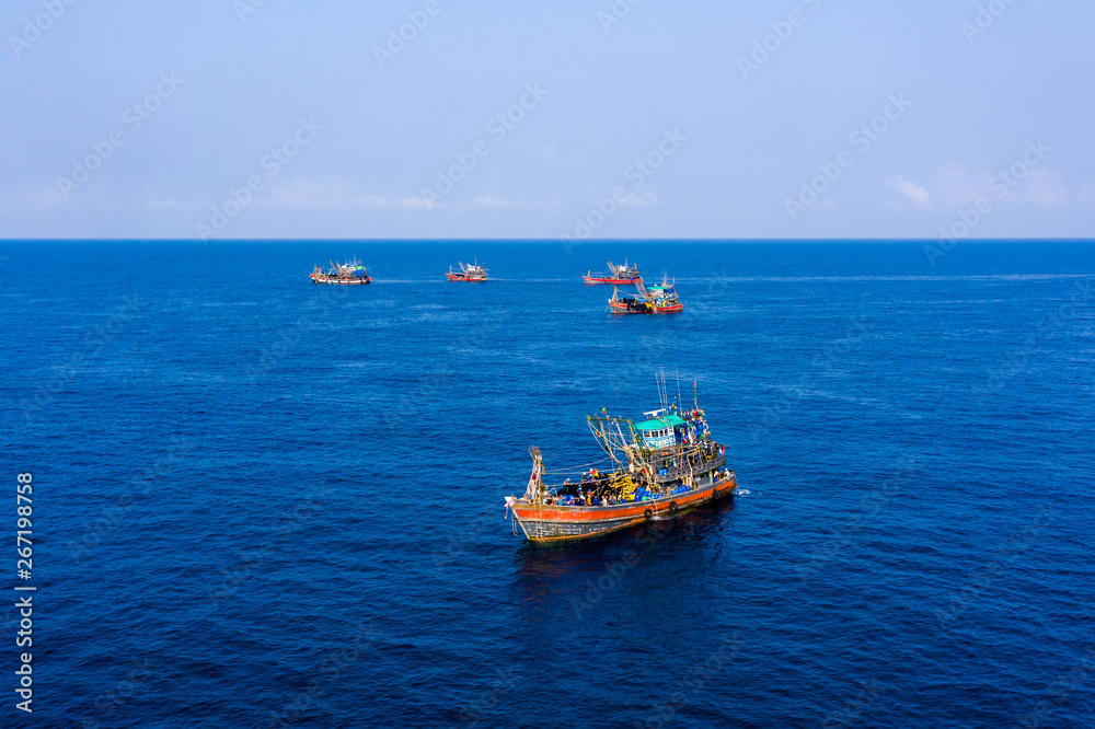 Overfishing - Aerial done view of a fleet of fishing trawlers clustered around a tiny, rocky island (Mergui, Myanmar) Overfishing - Aerial done view of a fleet of fishing trawlers clustered around a tiny, rocky island (Mergui, Myanmar)