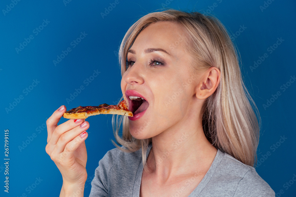 woman openung ovens and cut pizza with tomatoes, olives, mushrooms and cheese sausage on a blue background in the studio woman openung ovens and cut pizza with tomatoes, olives, mushrooms and cheese sausage on a blue background in the studio