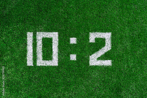 Football score 10:2.White numbers ten and two are drawn on the green grass,creative scoreboard