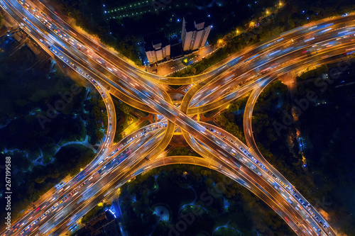 Aerial view of highway junctions shape letter x cross at night. Bridges, roads, or streets in connection or transportation concept. Structure of architecture in urban city, Shanghai Downtown, China.