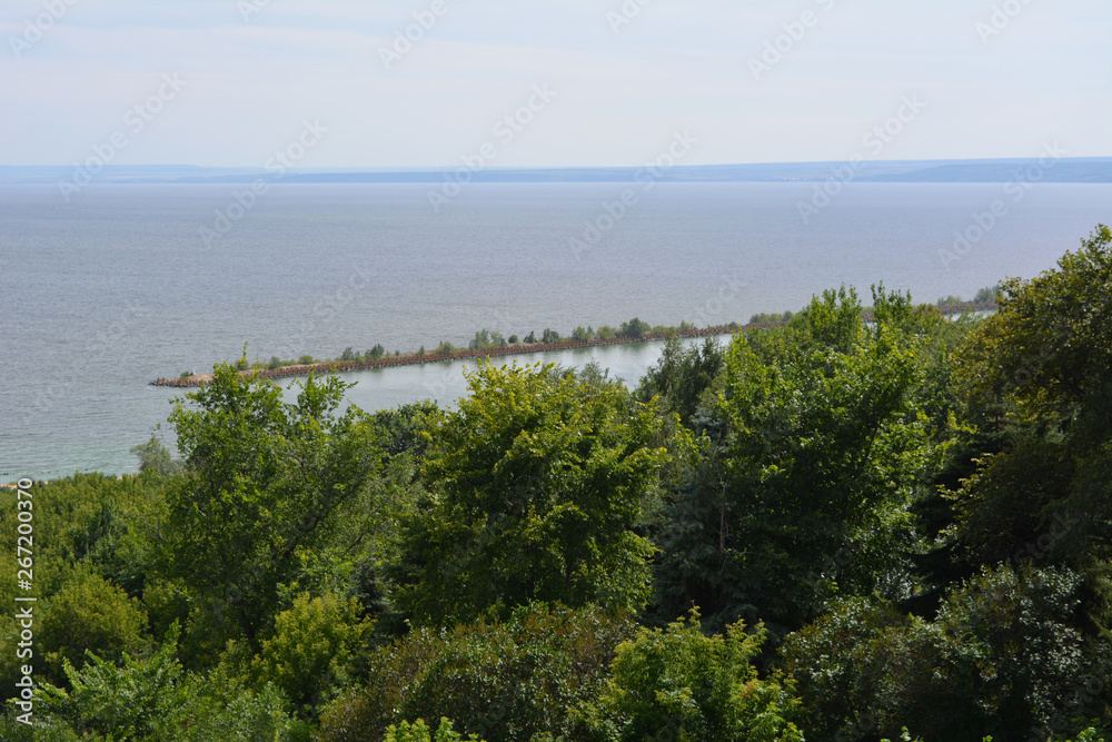 Summer landscape. View from top of the hill on river and trees on the coast.