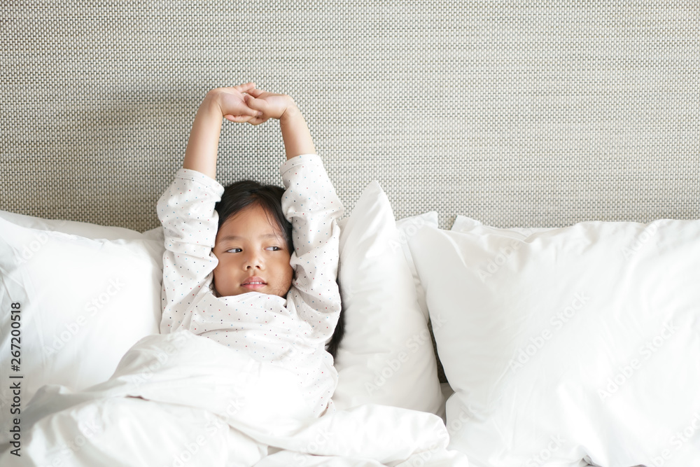 Asian child cute relax or kid girl sleep and smiling wake up with stretch  oneself for