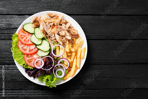 Photos Doner kebab or gyros on a plate with french fries, pita bread and salad