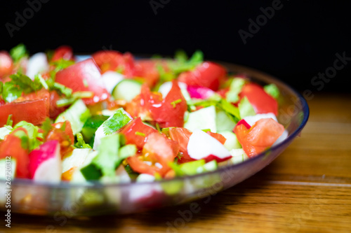 Close-up, delicious fresh vegetable salad cucumber tomatoes radishes cheese greens, vegetarian cuisine, healthy food, diet