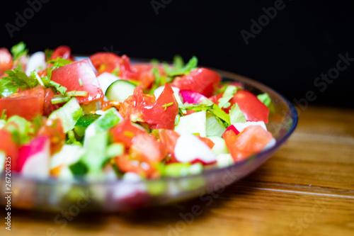 Close-up, delicious fresh vegetable salad cucumber tomatoes radishes cheese greens, vegetarian cuisine, healthy food, diet