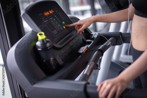 Closeup push start exercise treadmill cardio running workout at fitness gym of woman taking weight loss with machine aerobic for slim and firm healthy lifestyle.
