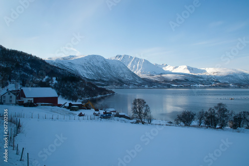 Coastline Norway  view over fish farm with late afternoon sun on mountains in background