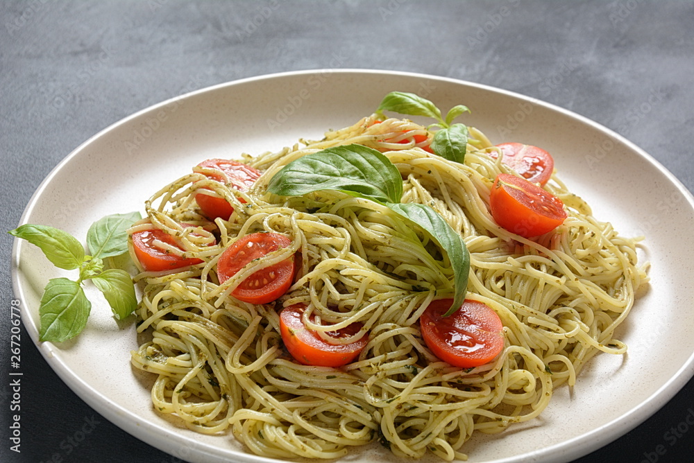 Pasta spaghetti with pesto sauce, fresh basil and cherry tomatoes . Italian traditional food Pasta spaghetti with pesto sauce, fresh basil and cherry tomatoes . Italian traditional food