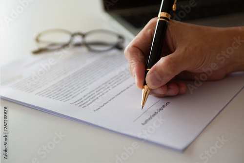 Businessman signing paper, male hand signature on business document photo