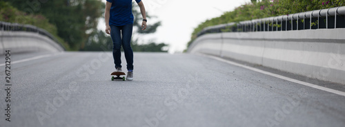 Skateboarder legs skateboarding on city road