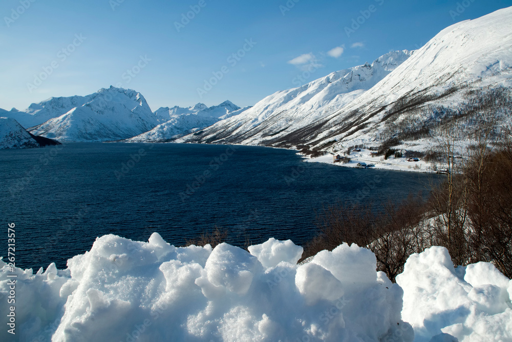 Coastline Norway, view of fjord with snowbank in foreground