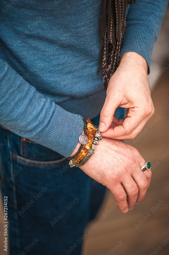 Male hand in a bracelet with a skull in the pocket of jeans close up and copy space Male hand in a bracelet with a skull in the pocket of jeans close up and copy space