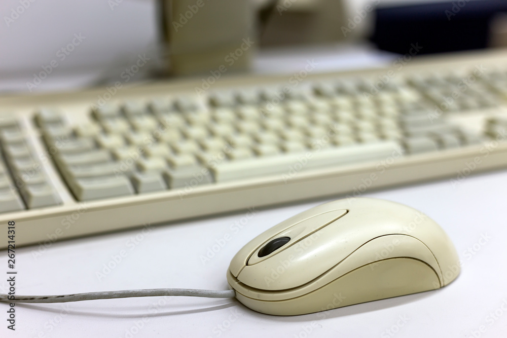 Close-up of white computer mouse on blurred PC keyboard background. Modern technology, information and communication concept. Close-up of white computer mouse on blurred PC keyboard background. Modern technology, information and communication concept.