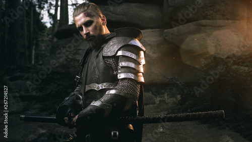 mystery scarface knight in armor with sword and crossbow in the forest