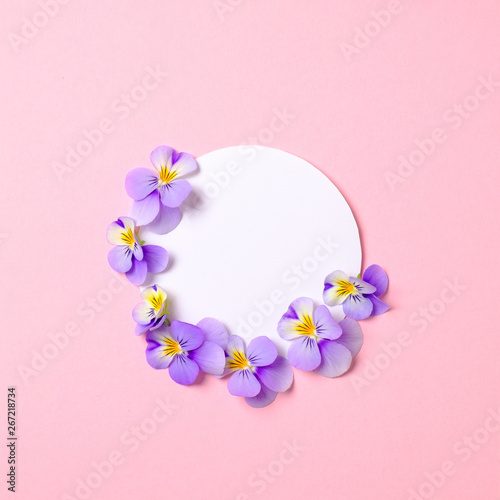 Creative flat lay composition  circle blank paper and blooming flower petals on pink background. Top view  floral round frame  abstract design. Invitation  greeting card or an element for your design