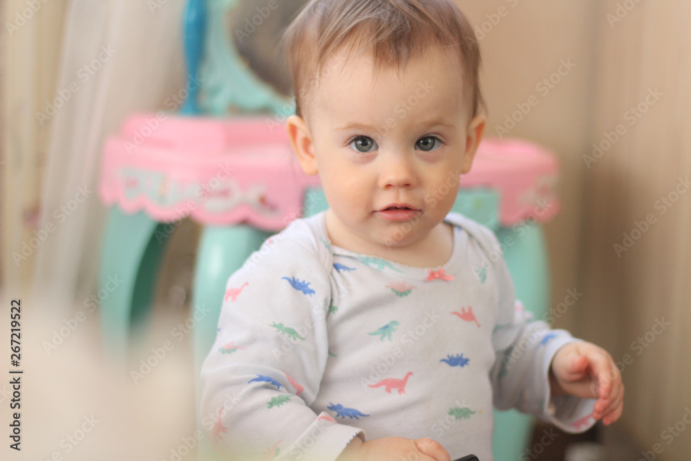 a small child plays in front of a toy mirror in the nursery a small child plays in front of a toy mirror in the nursery