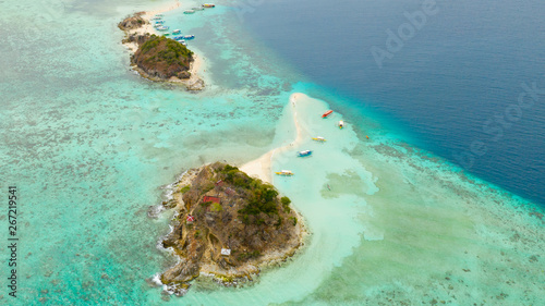 Small tropical island with a white beach. Clear sea with coral reef, top view. Philippines, Palawan