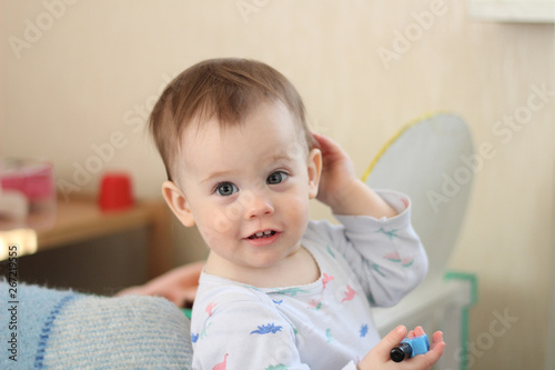 a small child plays in front of a toy mirror in the nursery