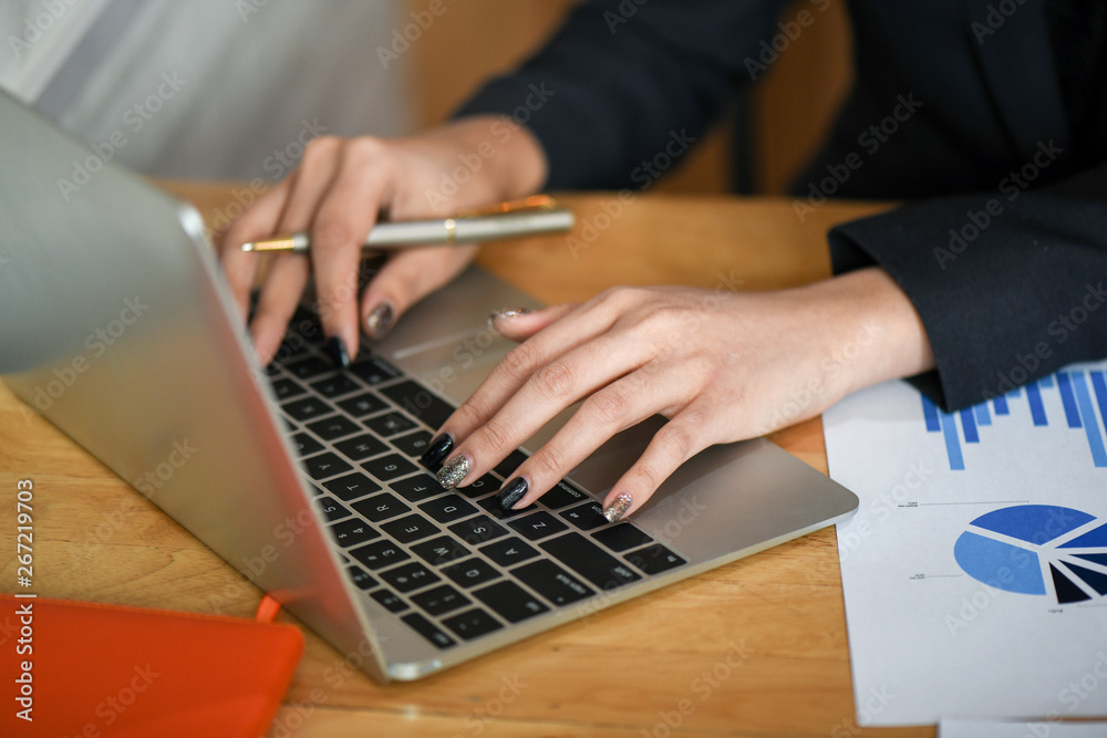 Female executives are using laptop computer in office.