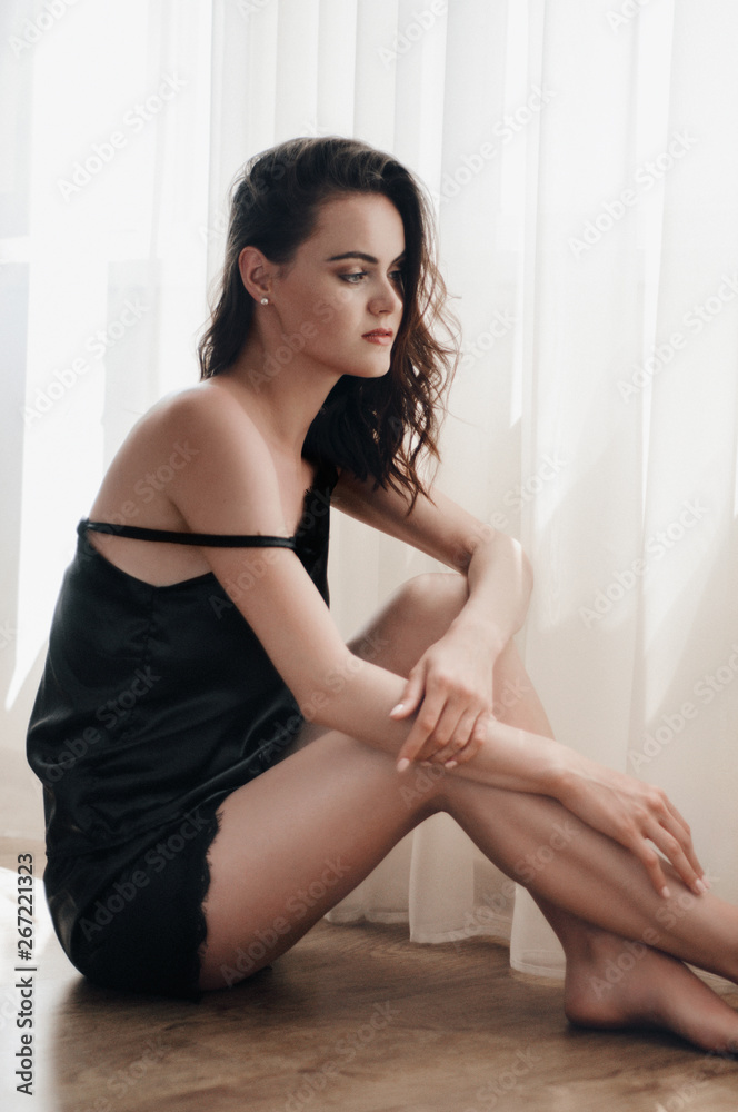 Portrait of young beautiful woman in sleepwear with softlight at window