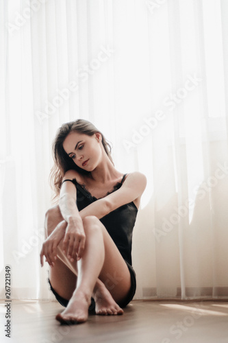 Portrait of young woman in sleepwear with soft ligth at window 