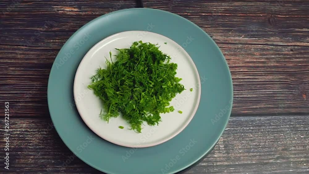 Cutted dill rotating on wooden background Cutted dill rotating on wooden background