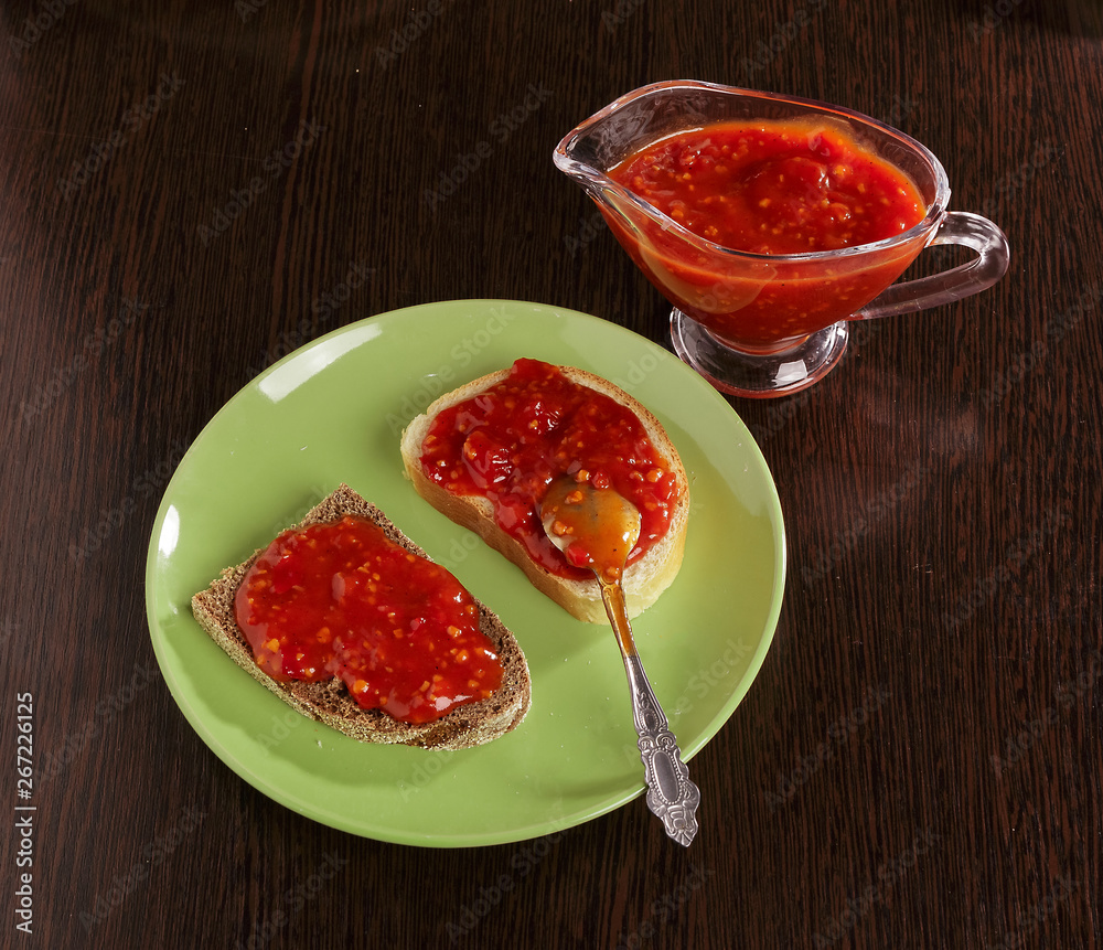 Pieces of rye bread and thick tomato sauce on a plate on the table. Pieces of rye bread and thick tomato sauce on a plate on the table.